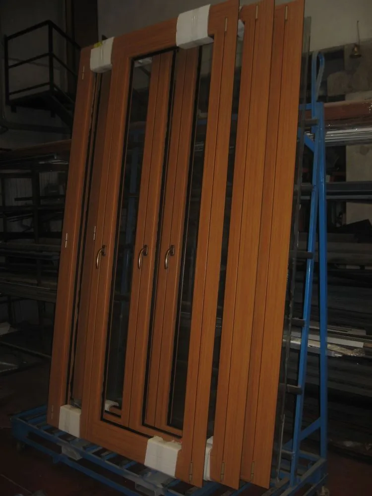 Serramenti in alluminio effetto legno appena prodotti, appoggiati su un cavalletto in officina.